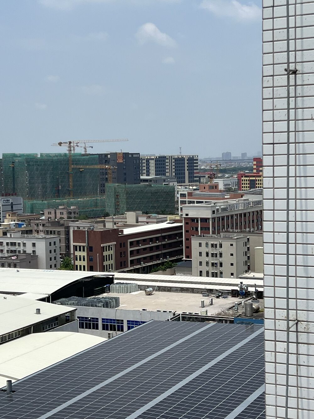 Plant rooftops with solar panels and the Zhongshan cityscape